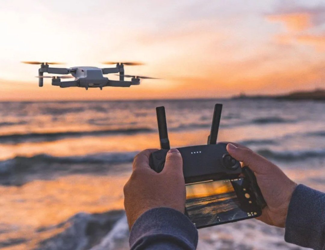 Control remoto con pantalla frente al mar al atardecer